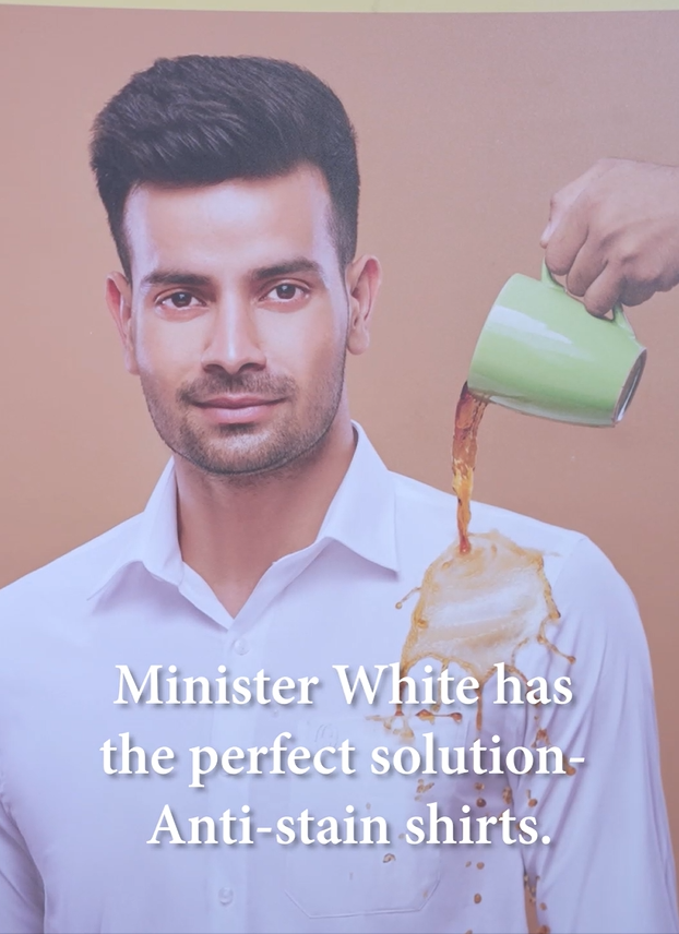 A Man wearing Minister White's Anti Stain Regular Fit shirt giving the demo of Anti stain shirt by pouring coffee on shirt and wiping the stain out